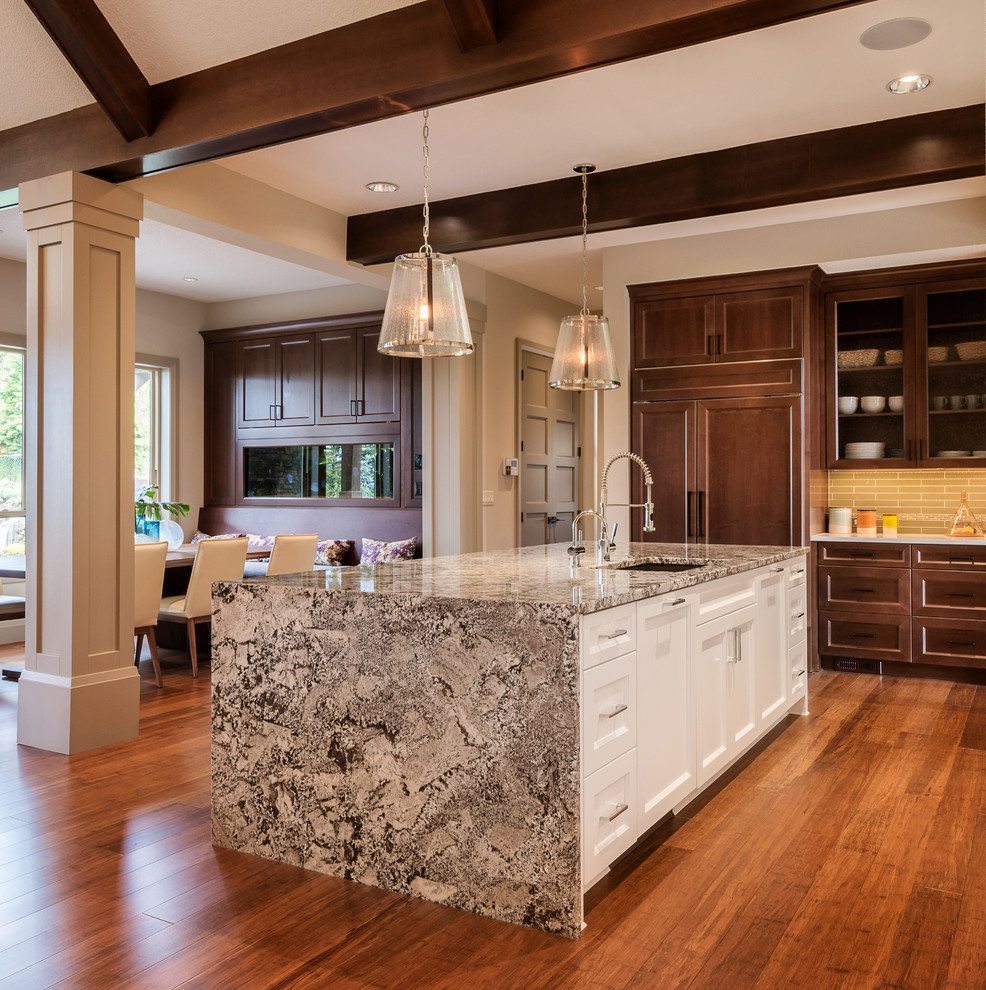 Large transitional l-shaped dark wood floor and brown floor eat-in kitchen photo in Toronto with an undermount sink, recessed-panel cabinets, dark wood cabinets, solid surface countertops, beige backsplash, ceramic backsplash, paneled appliances, an island and white countertops