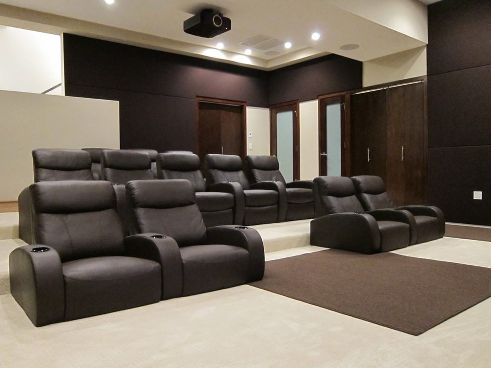 Photo of a large modern enclosed home theatre in Los Angeles with brown walls, carpet and a projector screen.