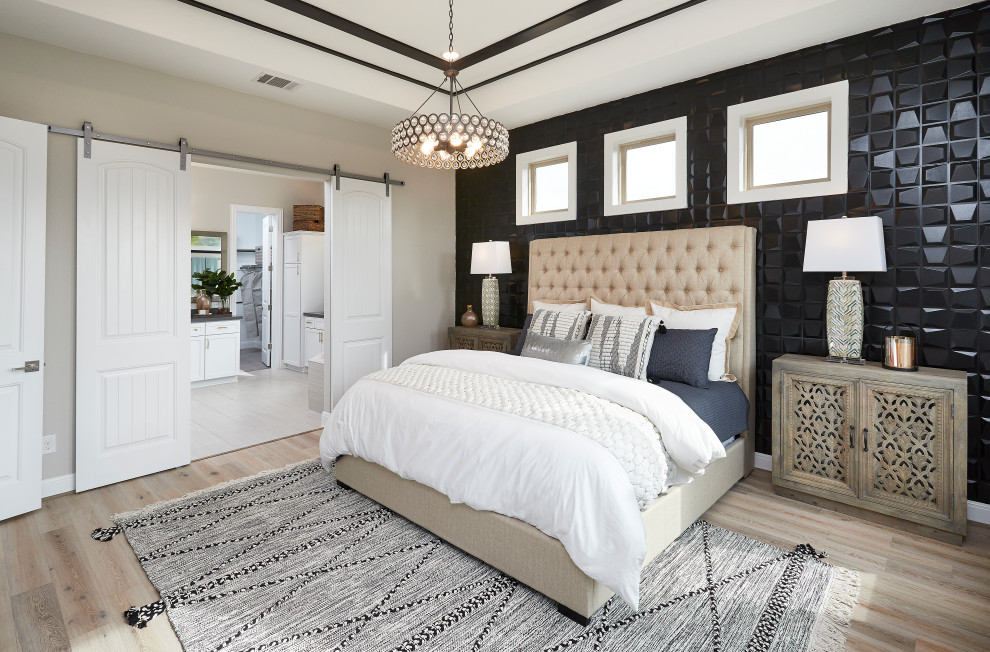 This is an example of a large contemporary master bedroom in Austin with beige walls, light hardwood floors and beige floor.