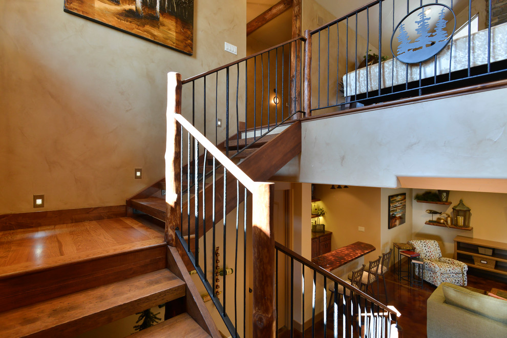 Photo of a mid-sized country wood u-shaped staircase in Denver with open risers and metal railing.