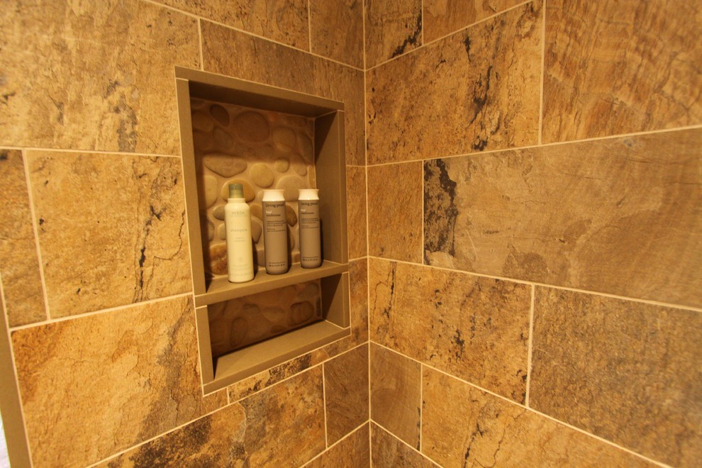 This is an example of a large country master bathroom in New York with shaker cabinets, distressed cabinets, an alcove shower, a one-piece toilet, multi-coloured tile, porcelain tile, beige walls, pebble tile floors, an undermount sink, engineered quartz benchtops, multi-coloured floor and a hinged shower door.