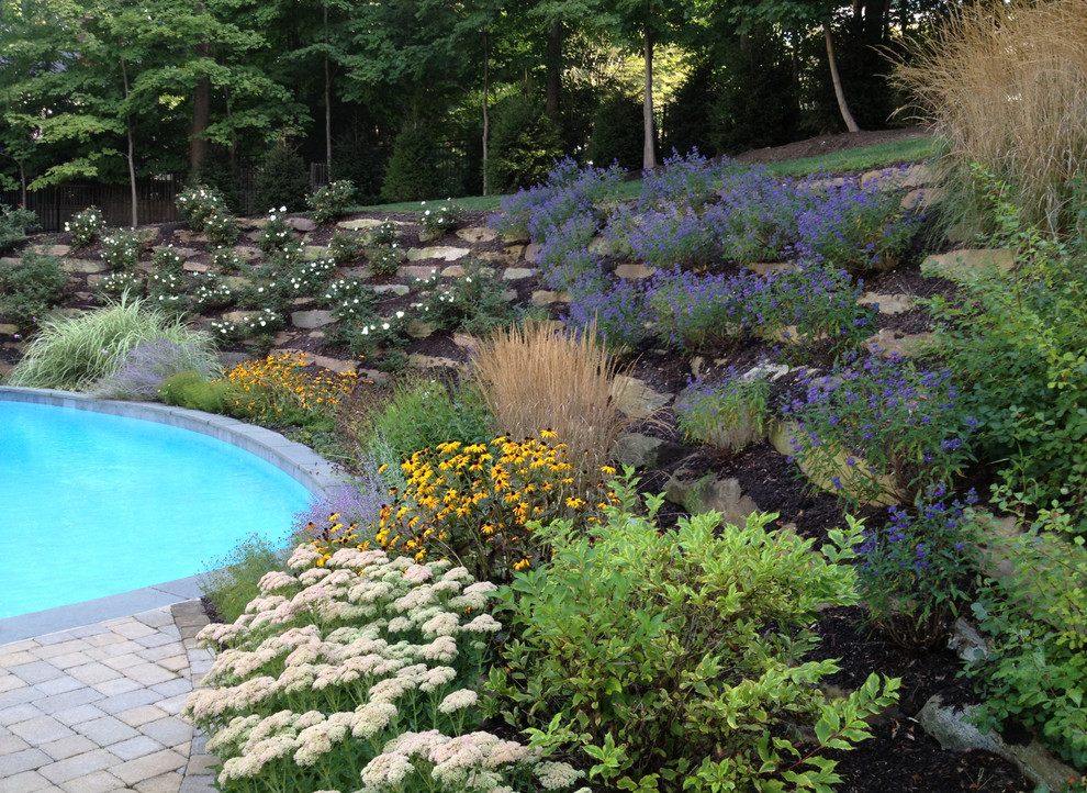 Design ideas for an eclectic backyard custom-shaped natural pool in New York with concrete pavers.