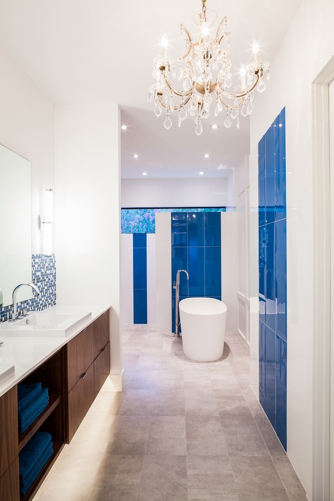 Photo of a contemporary bathroom in Houston with flat-panel cabinets, dark wood cabinets, a freestanding tub, blue tile and white walls.