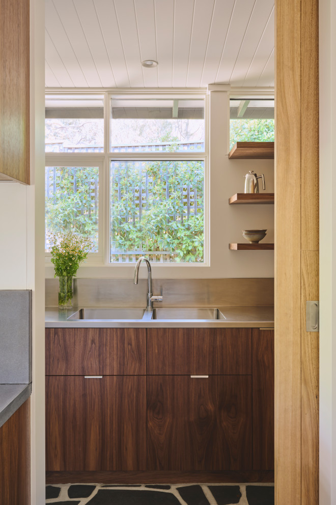 Mid-sized midcentury galley eat-in kitchen in Adelaide with a double-bowl sink, flat-panel cabinets, dark wood cabinets, stainless steel benchtops, grey splashback, metal splashback, stainless steel appliances, slate floors, with island, grey floor, grey benchtop and wood.