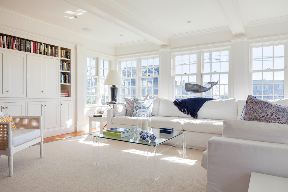 Photo of a large beach style living room in Providence with white walls, no fireplace, a library, carpet and brown floor.