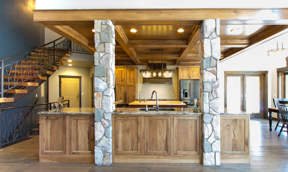 Inspiration for a rustic brown floor kitchen remodel with an undermount sink, flat-panel cabinets, medium tone wood cabinets, quartz countertops, stainless steel appliances and two islands