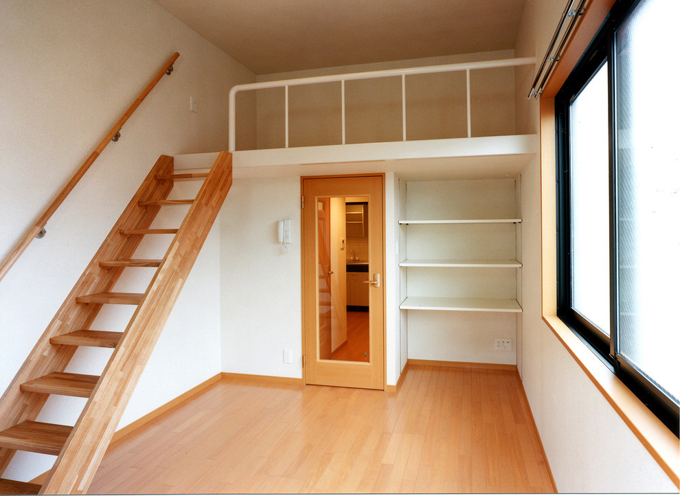 Ispirazione per una camera da letto stile loft minimalista di medie dimensioni con pareti bianche, pavimento in compensato e pavimento beige