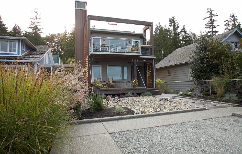 This is an example of a small contemporary front yard full sun xeriscape for summer in Seattle with natural stone pavers.