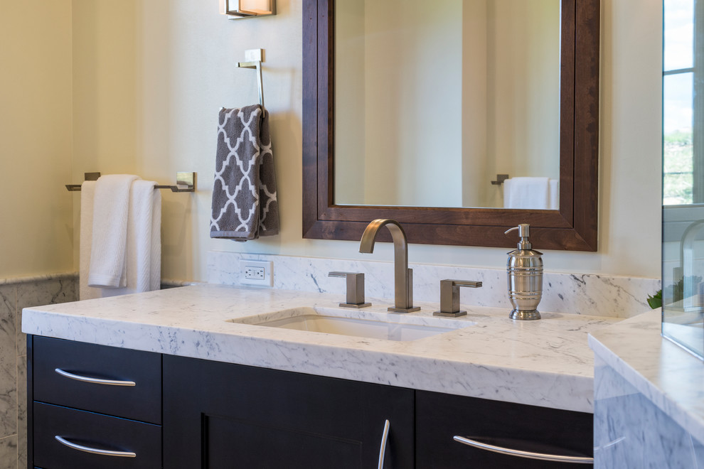 This is an example of a large transitional master bathroom in Denver with a drop-in sink, shaker cabinets, black cabinets, marble benchtops and beige walls.