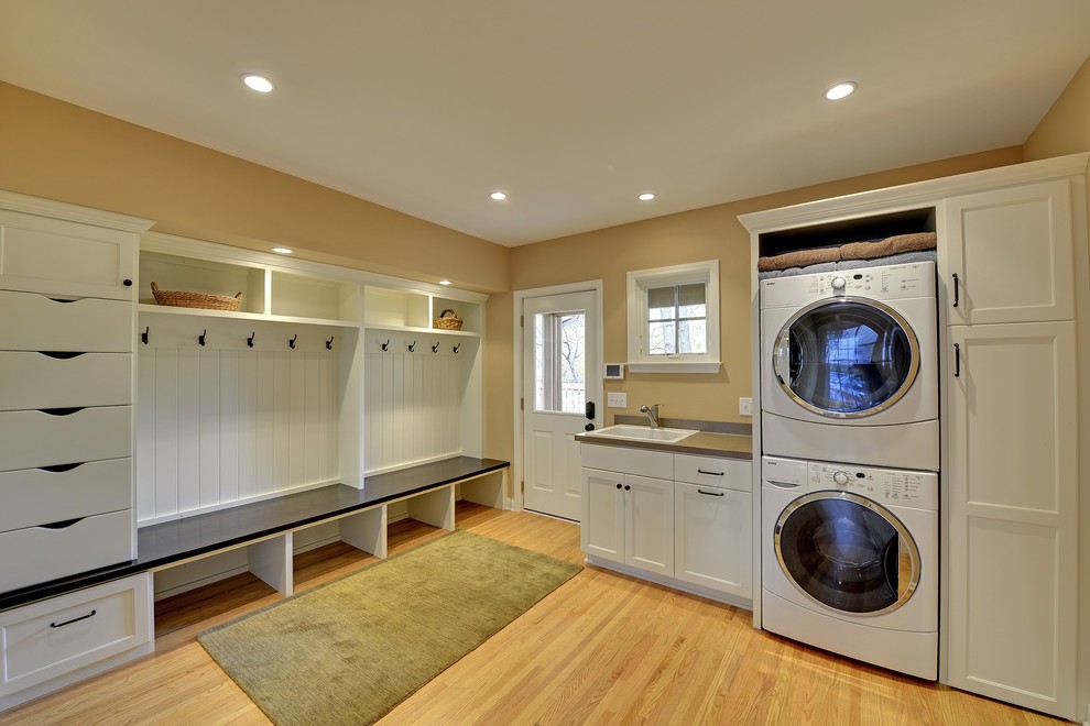 This is an example of a traditional laundry room in Minneapolis with a stacked washer and dryer.