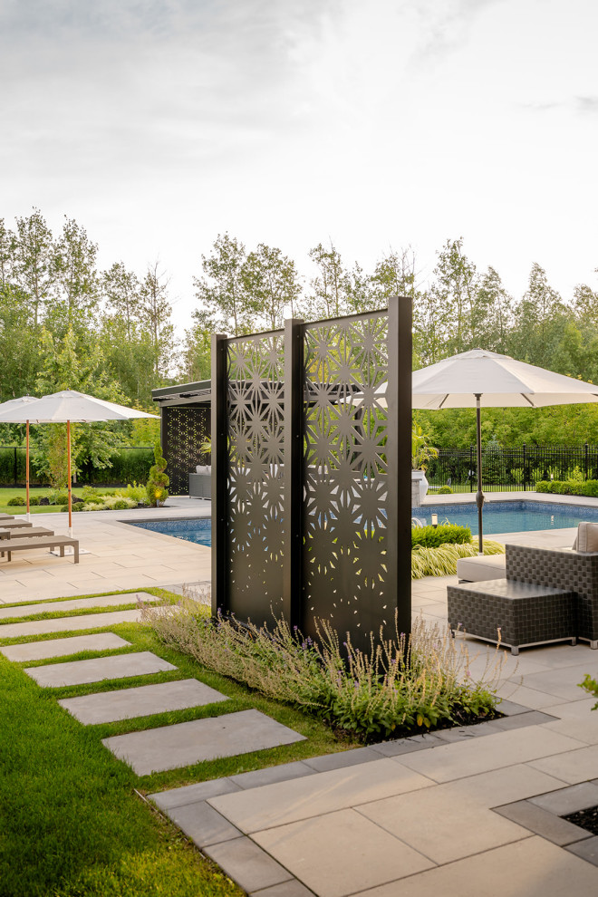 Inspiration for a large transitional backyard concrete paver and rectangular lap pool landscaping remodel in Toronto