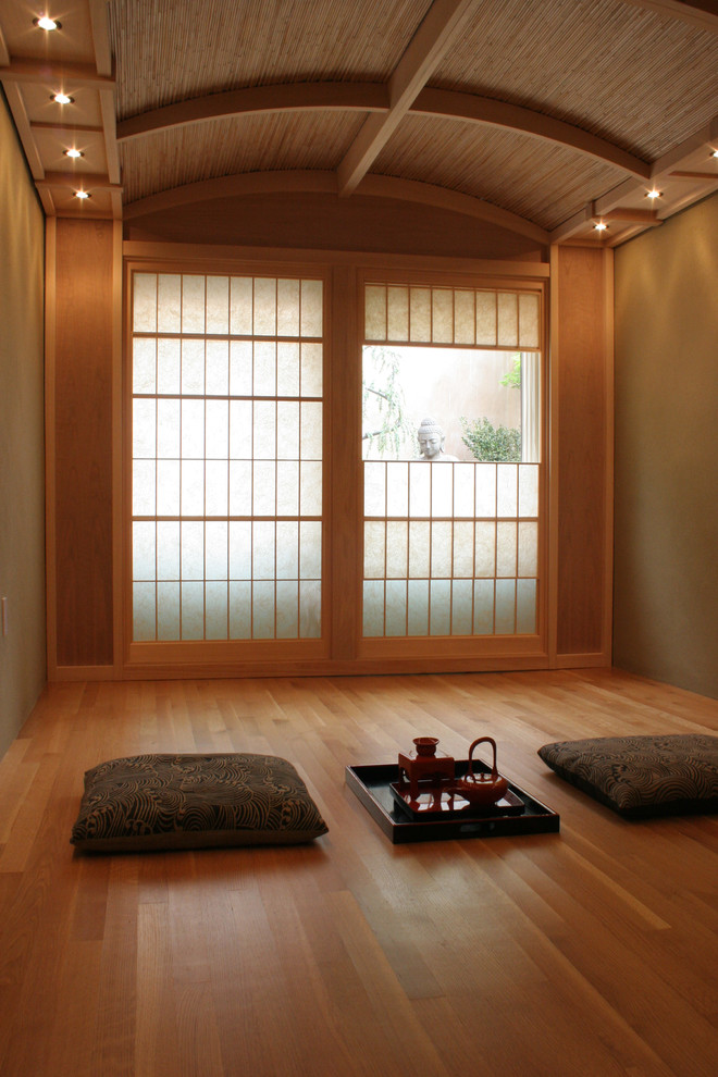 This is an example of an asian living room in San Francisco with brown walls and medium hardwood floors.
