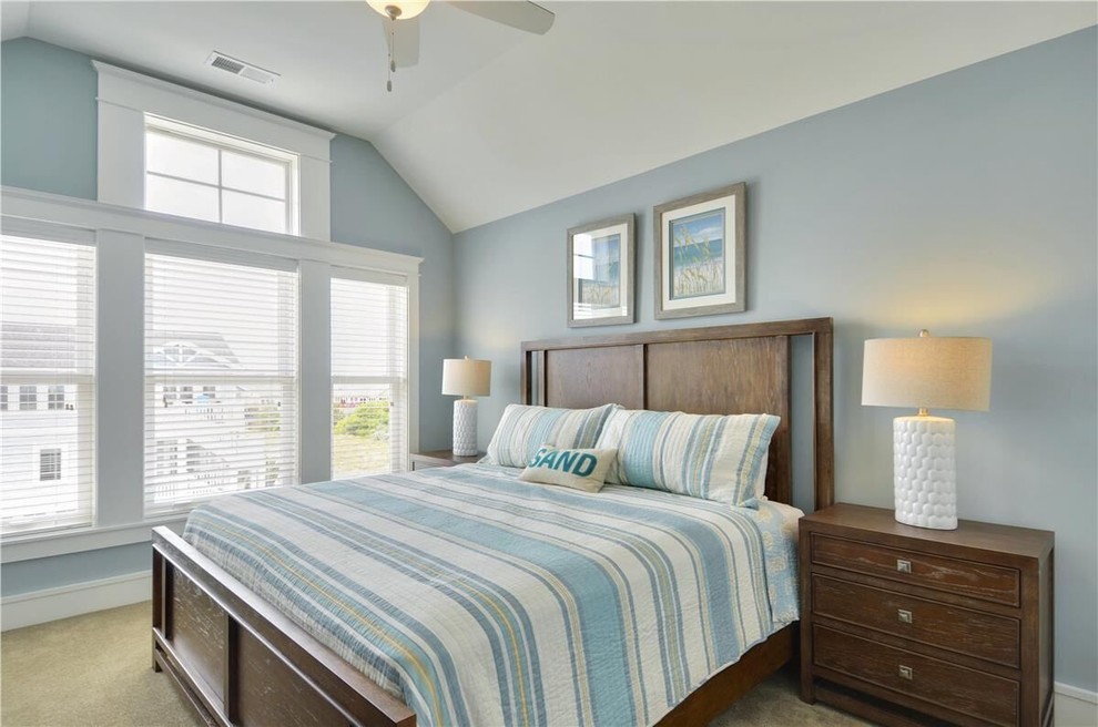 This is an example of a mid-sized beach style guest bedroom in Other with blue walls, carpet and no fireplace.