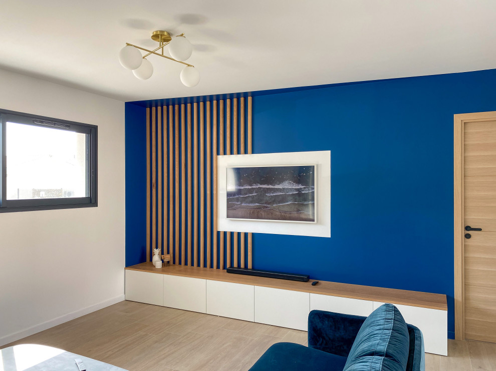 Diseño de salón abierto contemporáneo de tamaño medio sin chimenea con paredes azules, suelo de baldosas de cerámica, televisor colgado en la pared y suelo beige