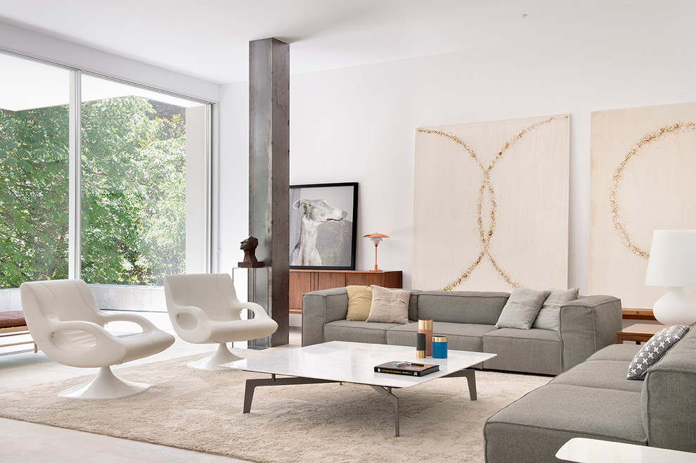 Large contemporary open concept living room in Madrid with white walls and beige floor.