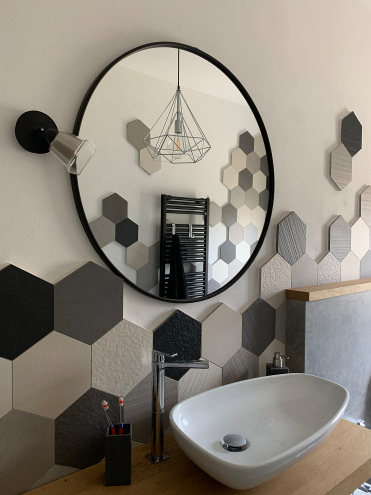Photo of a mid-sized master bathroom in Florence with open cabinets, grey cabinets, a drop-in tub, a shower/bathtub combo, a one-piece toilet, multi-coloured tile, mosaic tile, white walls, porcelain floors, a vessel sink, wood benchtops, grey floor, a hinged shower door, a single vanity and a floating vanity.