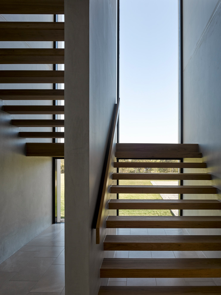 Large contemporary wood u-shaped staircase in Brisbane with wood railing.