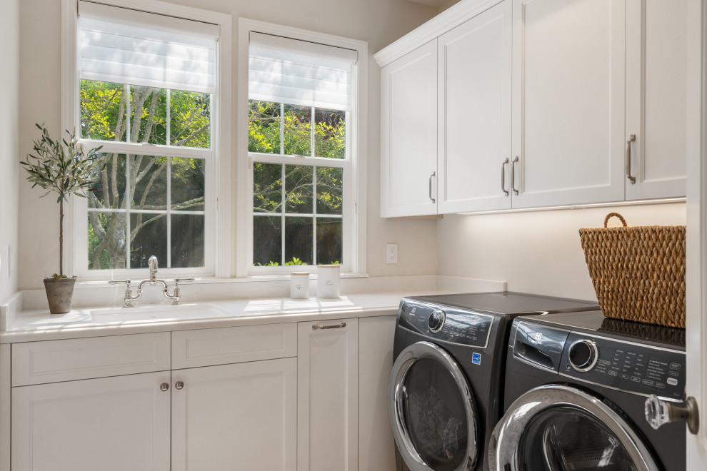 Mid-sized traditional dedicated laundry room in San Francisco with an undermount sink, shaker cabinets, medium hardwood floors and a side-by-side washer and dryer.