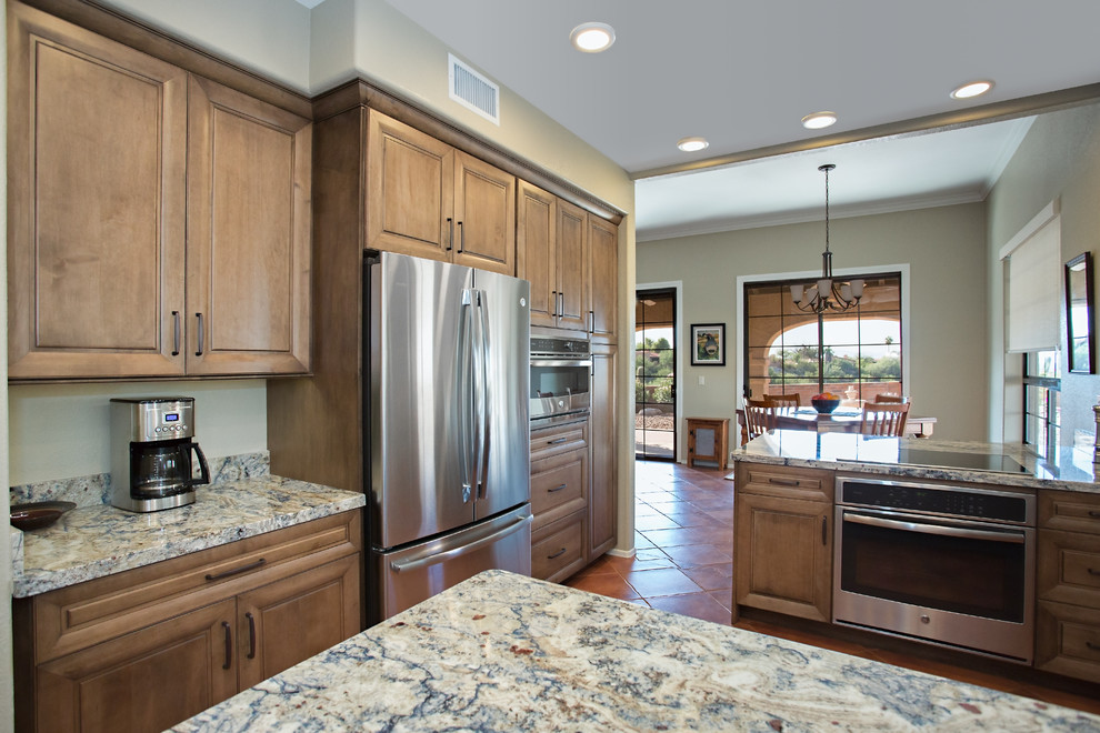 Inspiration for a large traditional eat-in kitchen in Phoenix with raised-panel cabinets, brown cabinets, granite benchtops, stainless steel appliances, a peninsula and turquoise benchtop.
