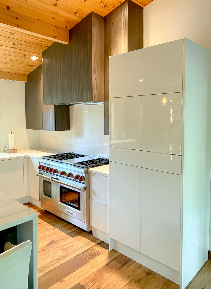 Immagine di una grande cucina minimalista con ante lisce, ante in legno bruno, top in quarzo composito, paraspruzzi bianco, paraspruzzi in quarzo composito, pavimento in legno massello medio e top bianco