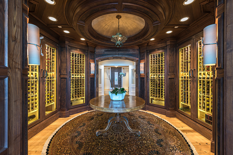 Photo of a traditional wine cellar in Miami with light hardwood floors, display racks and brown floor.