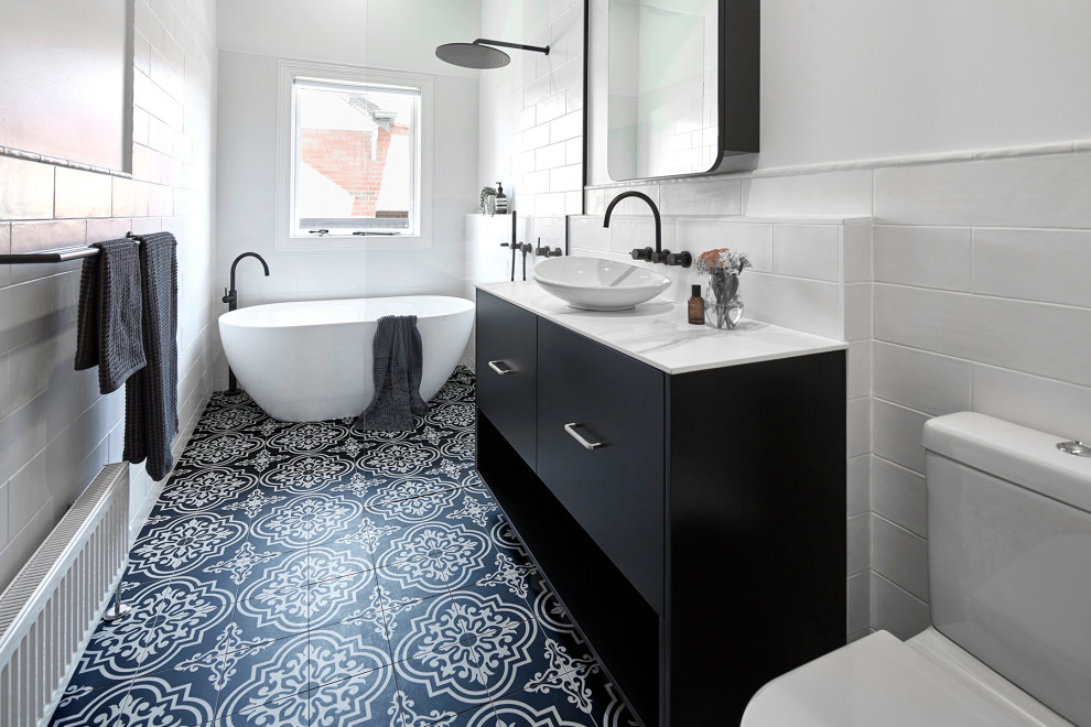 Small contemporary 3/4 wet room bathroom in Melbourne with black cabinets, a freestanding tub, a wall-mount toilet, white tile, subway tile, white walls, an undermount sink, laminate benchtops, multi-coloured floor, an open shower, white benchtops, porcelain floors and flat-panel cabinets.