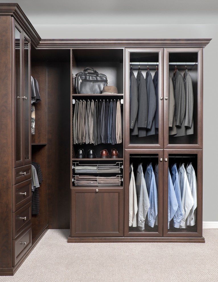 Mid-sized transitional men's walk-in wardrobe in Phoenix with raised-panel cabinets, dark wood cabinets and carpet.