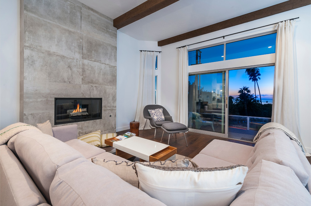 Photo of a beach style open concept living room in San Diego with medium hardwood floors and a tile fireplace surround.