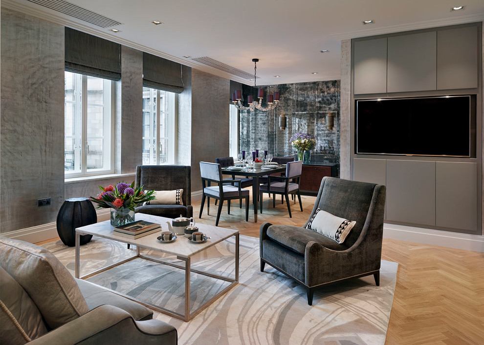 Design ideas for an expansive transitional formal open concept living room in London with grey walls, light hardwood floors, a wall-mounted tv and beige floor.