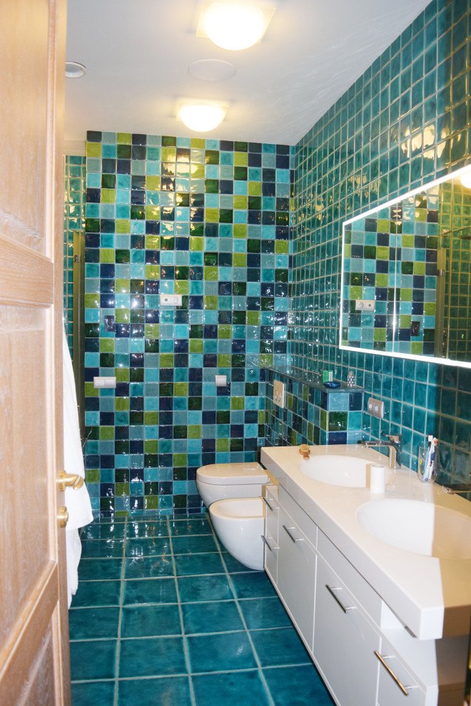 Пример оригинального дизайна: туалет среднего размера: освещение в стиле фьюжн с стеклянными фасадами, белыми фасадами, инсталляцией, разноцветной плиткой, керамической плиткой, разноцветными стенами, полом из керамической плитки, накладной раковиной, столешницей из искусственного камня, синим полом, белой столешницей, напольной тумбой, многоуровневым потолком и панелями на стенах