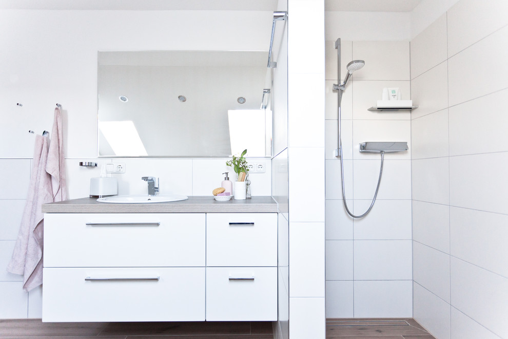 Großes Modernes Kinderbad mit Keramikfliesen, flächenbündigen Schrankfronten, weißen Schränken, offener Dusche, weißen Fliesen, weißer Wandfarbe, Keramikboden, Einbauwaschbecken, Laminat-Waschtisch, beigem Boden, beiger Waschtischplatte, Einzelwaschbecken und schwebendem Waschtisch in München