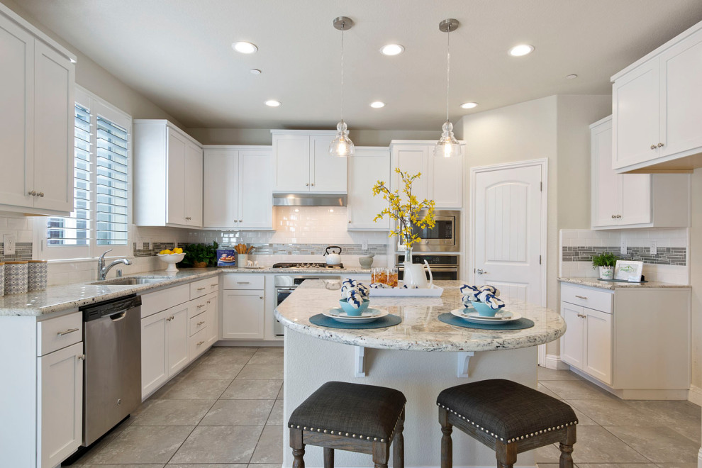 Kitchen - large transitional u-shaped gray floor kitchen idea in Sacramento with an undermount sink, shaker cabinets, white cabinets, white backsplash, stainless steel appliances, an island and gray countertops