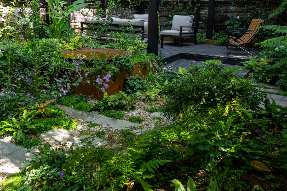 Design ideas for a small contemporary backyard shaded garden for summer in London with natural stone pavers.