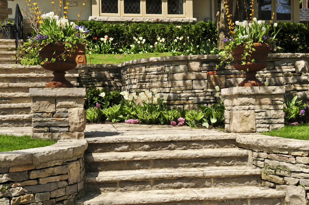 This is an example of a mid-sized traditional front yard garden in New York with natural stone pavers.