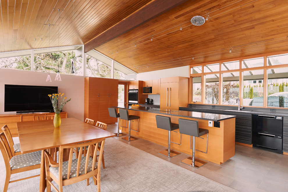 This is an example of a mid-sized midcentury open plan kitchen in Seattle with an undermount sink, flat-panel cabinets, grey cabinets, cement tiles, with island, beige floor, grey benchtop, window splashback and panelled appliances.