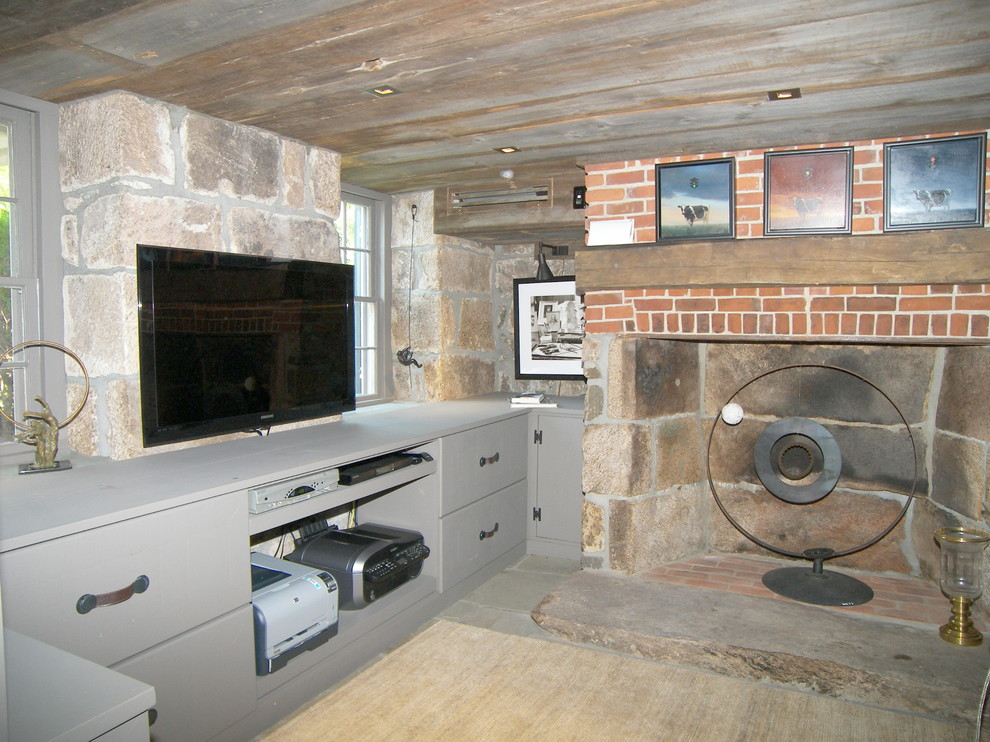 Mid-sized country fully buried basement in New York with a standard fireplace, brown walls, slate floors and a stone fireplace surround.