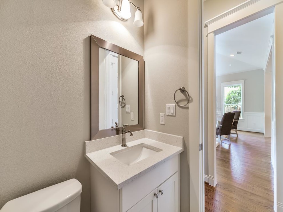 Inspiration for a small traditional 3/4 bathroom in Houston with glass-front cabinets, white cabinets, a one-piece toilet, porcelain floors, an integrated sink and engineered quartz benchtops.