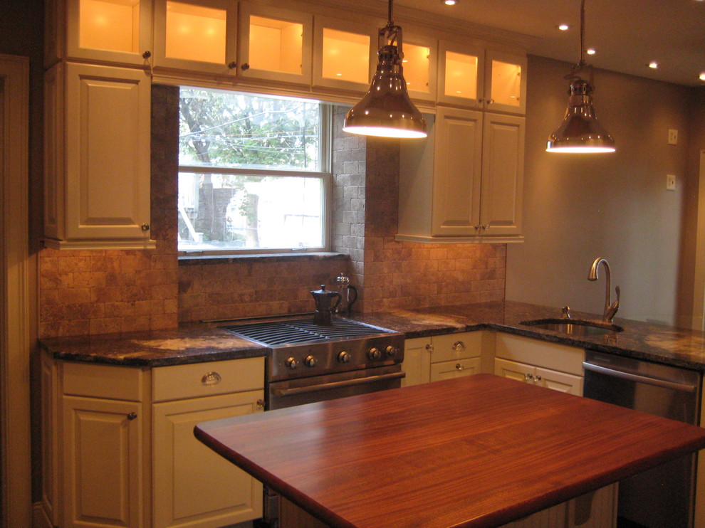 Transitional l-shaped eat-in kitchen photo in Philadelphia with a single-bowl sink, raised-panel cabinets, white cabinets, granite countertops, brown backsplash, stone tile backsplash and stainless steel appliances