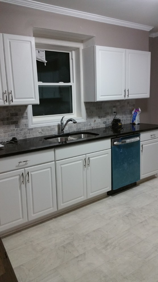 Inspiration for a small traditional l-shaped separate kitchen in Toronto with an undermount sink, raised-panel cabinets, white cabinets, granite benchtops, grey splashback, cement tile splashback, stainless steel appliances, ceramic floors and no island.