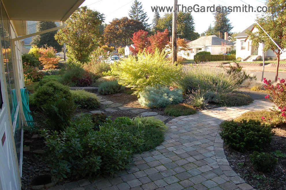 This is an example of a small eclectic front yard full sun garden in Portland with a garden path and concrete pavers.