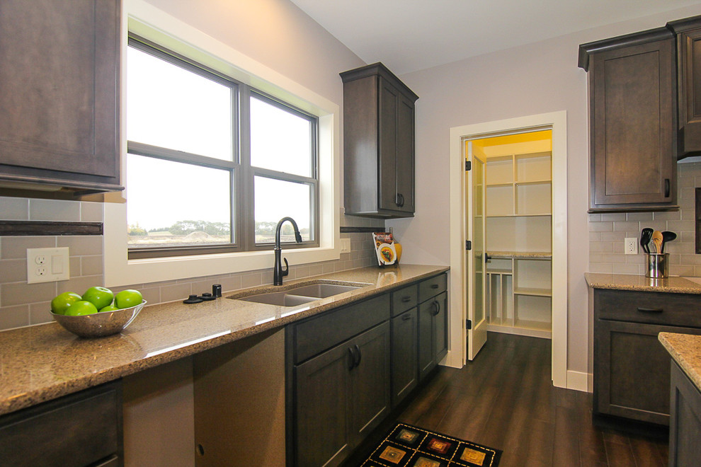 Mid-sized transitional u-shaped open concept kitchen photo with flat-panel cabinets, gray cabinets, quartz countertops, white backsplash, subway tile backsplash and an island