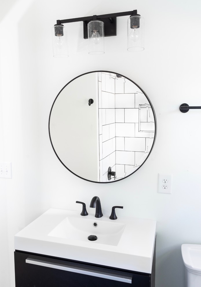 This is an example of a small midcentury master bathroom in Charlotte with black cabinets, a shower/bathtub combo, white tile, a shower curtain and white benchtops.