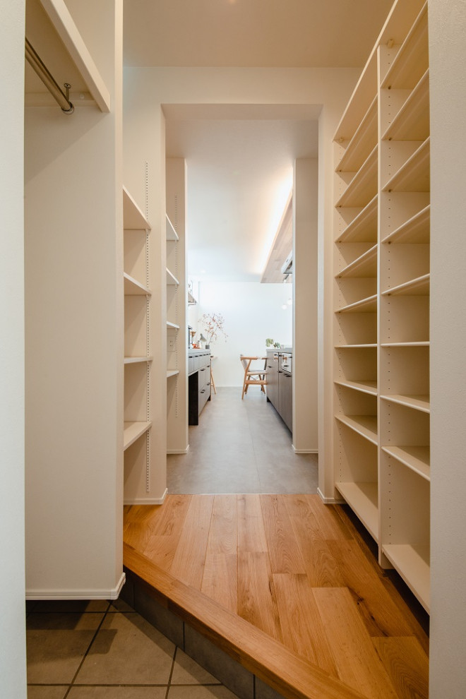 This is an example of a scandi hallway in Other with white walls, medium hardwood flooring, a single front door, a medium wood front door and brown floors.