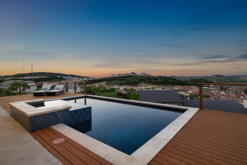 Photo of a mid-sized transitional backyard rectangular lap pool in Austin with a hot tub and decking.