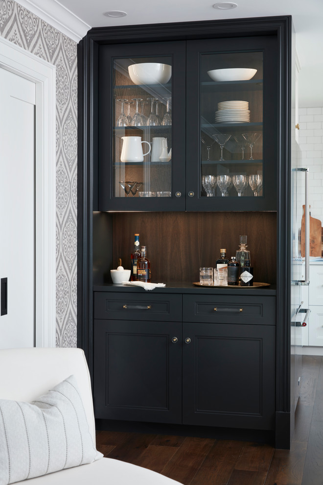 This is an example of a small transitional single-wall home bar in Toronto with no sink, glass-front cabinets, black cabinets, brown splashback, timber splashback, dark hardwood floors, brown floor and black benchtop.