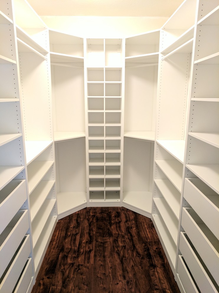 Example of a mid-sized transitional dark wood floor and brown floor walk-in closet design with open cabinets and white cabinets