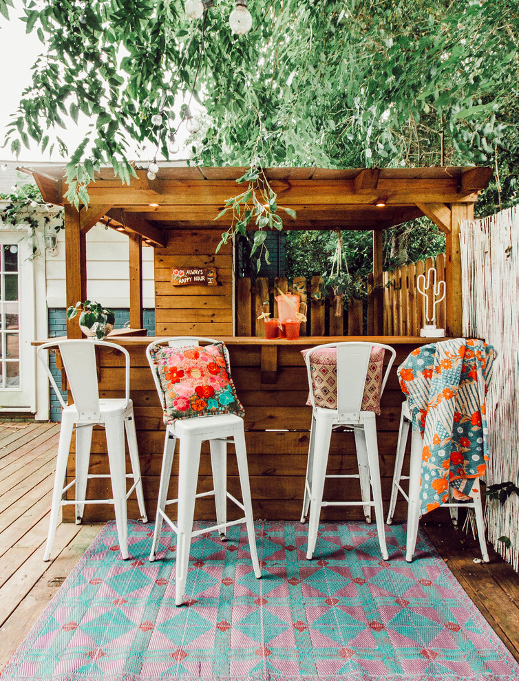 Photo of an eclectic backyard deck in Nashville with a pergola.