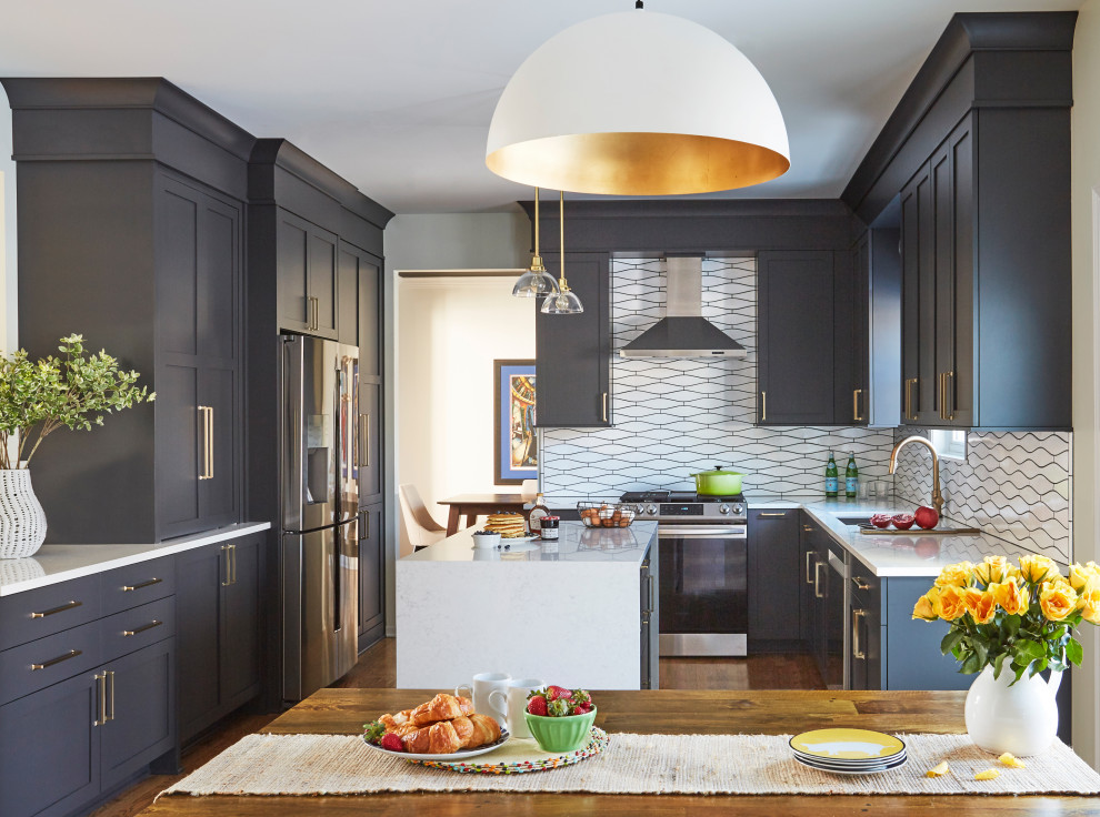 Design ideas for a large transitional u-shaped eat-in kitchen in Chicago with an undermount sink, shaker cabinets, blue cabinets, quartz benchtops, white splashback, ceramic splashback, stainless steel appliances, medium hardwood floors, with island, brown floor and white benchtop.