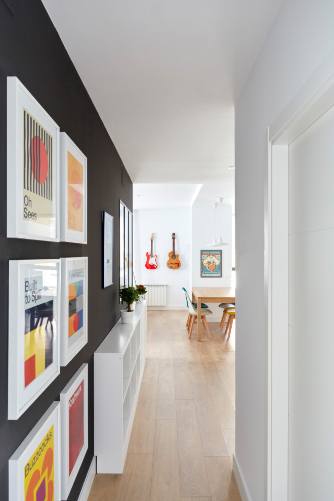 Mid-sized modern hallway in Madrid with white walls and light hardwood floors.