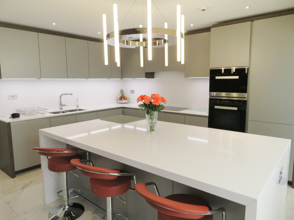 Photo of a mid-sized contemporary l-shaped kitchen in London with a double-bowl sink, flat-panel cabinets, grey cabinets, stainless steel appliances, marble floors, with island and white floor.